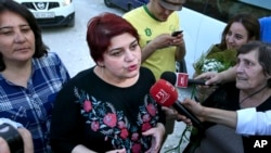 FILE - Khadija Ismayilova, then a reporter for Radio Free Europe/Radio Liberty, speaks to journalists after her release from prison in Baku, Azerbaijan, May 25, 2016. 