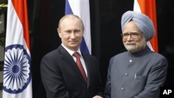 Presiden Rusia Vladimir Putin (kiri) disambut PM India Manmohan Singh di kediamannya di New Delhi, India (24/12). 