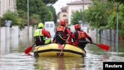 FILE - Firefighters transport food and water to people who are still in their homes after heavy rains hit Italy's Emilia Romagna region, in Lugo, Italy, May 19, 2023. 