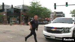 Un agente de policía corre en el lugar del tiroteo durante la caravana del 4 de Julio en Highland Park, Estados Unidos.