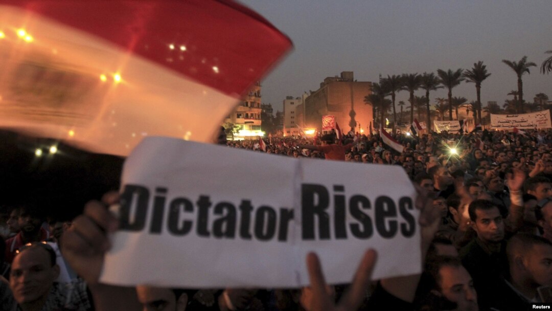 Para demonstran anti Presiden Morsi melakukan unjuk rasa di Lapangan Tahrir, Kairo sambil membawa spanduk yang menyamakan Morsi sebagai diktator (27/11). 