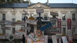 A worker adjusts his glove before removing road signs left by French farmers overnight on the gate of the Deux Sevres&#39; prefecture in Niort, southwestern France.