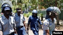 Amapholisa abikwa ukuthi atshaye uDouglas Coltart oligqwetha ngesikhathi esenkambeni yamapholisa. REUTERS/Philimon Bulawayo
