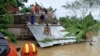 Warga berada di atas atap untuk menghindari banjir, sambil menunggu evakuasi dari tim penyelamat di Libon, provinsi Albay, Filipina, 23 Oktober 2024 (foto: dok). Filipina di urutan teratas negara yang paling berisiko terhadap krisis iklim. 