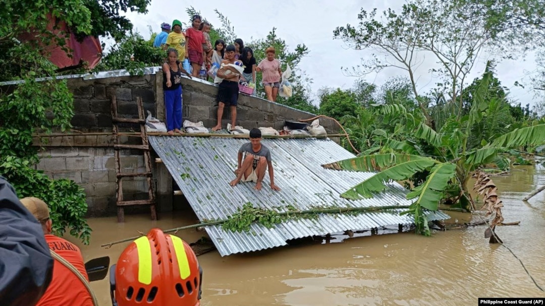 Người dân leo lên mái nhà để tránh lũ lụt và chờ được giải cứu ở Libon, tỉnh Albay, Philippines, vào ngày 23 tháng 10 năm 2024.