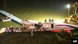 Badan pesawat TransAsia Airways ditarik ke bantaran sungai setelah jatuh di Taipei, Taiwan (4/2). 