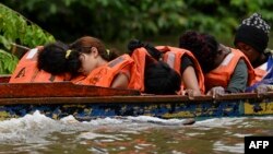 En esta foto de archivo, tomada el 12 de octubre de 2022, un grupo de migrantes venezolanos duerme en su viaje por río en la primera frontera del Darién, en Panamá. Luis ACOSTA / AFP