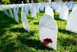 White plastic tombstone-shaped pieces are lined up as a temporary memorial to some of Miami's victims of the coronavirus at Simonhoff Floral Park, Oct. 14, 2020, in the Liberty City neighborhood of Miami.
