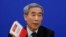 中国人大常委会副秘书长李飞在记者会上手持中国法律书（2016年11月7日）