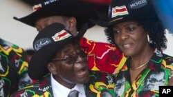 Le président zimbabwéen Robert Mugabe sourit en assistant à ses célébrations du 93e anniversaire avec sa femme Grace, à droite, à Matopos, dans la banlieue de Bulawayo, 25 février 2017