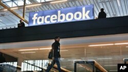 FILE - Facebook logo is displayed in a start-up companies gathering at Paris' Station F, in Paris, Jan. 17, 2017.