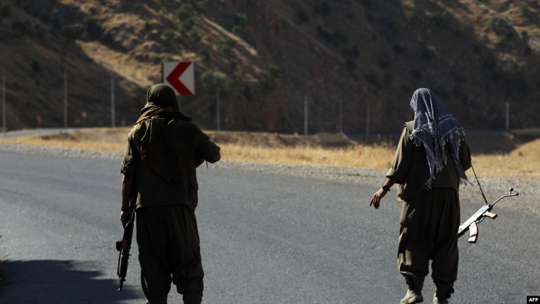 Seorang anggota Partai Pekerja Kurdistan membawa senjata semi-otomatis di sebuah jalan di Pegunungan Qandil, di utara Irak, 22 Juni 2018.