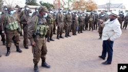 In this photo supplied by the Mozambican Presidency, President Filipe Nyusi, right, during a visit to his Defence and Security Force Troops in Northern Mozambique, July 9, 2021.