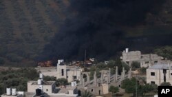 Smoke fills the sky after Israeli settlers set fire to the properties of Palestinian villagers in the West Bank village of Al-Mughayyir on April 13, 2024.