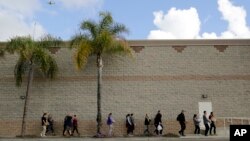 Des bénévoles apportent des dons à un groupe de migrants sans papiers qui cherchent du travail à San Diego, en Californie, le 4 février 2017.