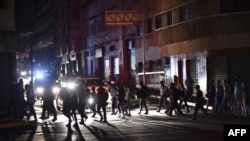 People cross a street during a power cut in Caracas, Venezuela, March 7, 2019.