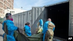 FILE - National Guard members assisting with processing COVID-19 deaths, placing them into temporary storage at the medical examiner-coroner's office in Los Angeles, Jan. 12, 2021. (LA County Department of Medical Examiner-Coroner)