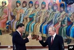 Presiden Rusia Vladimir Putin, kanan, dan Presiden China Xi Jinping bersulang saat makan malam di The Palace of the Facets, sebuah gedung di Moscow Kremlin, Rusia, 21 Maret 2023. (Foto: via AP)