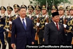 Presiden China Xi Jinping dan Presiden Prabowo Subianto meninjau barisan kehormatan selama upacara penyambutan di Balai Agung Rakyat di Beijing, China, 9 November 2024. (Foto: Florence Lo/Pool/Reuters)