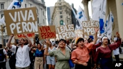 FILE - Argentinian Peronists rally at the Plaza de Mayo with cardboard posters reading in Spanish; "Long live Peron," "Loyal to Peron," "We love Peron," marking Peronist Loyalty Day, in Buenos Aires, Argentina, Oct. 17, 2013.