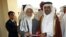 Qatari Assistant Minister for Foreign Affairs Ali bin Fahd al-Hajri (r) and Jan Mohammad Madani, (l) one of the Taliban officials cut the ribbon at the official opening ceremony of a Taliban office in Doha, Qatar, June 18, 2013. 