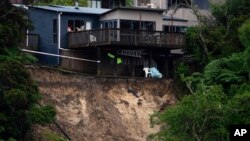 A landslip caused by flood water undermines a house in Auckland, Jan. 28, 2023.