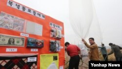 8일 군사분계선 근교 마을에서 대북전단과 생필품을 날려보내는 한국 민간단체 회원들.
