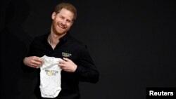 Britain's Prince Harry holds a baby suit during the official launch of the one year countdown to the Invictus Games The Hague 2020, in The Hague, Netherlands, May 9, 2019. 