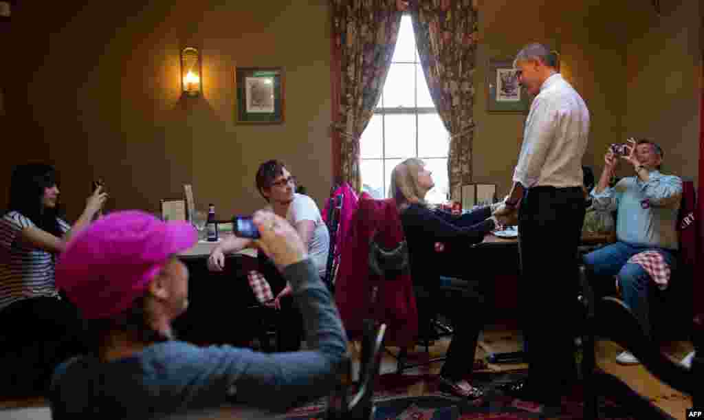 Barack Obama shakes hands with customers at the Common Man restaurant in Merrimack, New Hampshire, October 27, 2012, during an unscheduled campaign stop. 