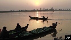 Grocery vendors sit on their boats to cross Irrawaddy river in Myitkyina, February 25, 2012, in Myitkyina, Kachin State, northern Burma.