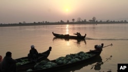 Groceries vendors sit on their boat to cross Irrawaddy river in Myitkyina, February 25, 2012, in Myitkyina, Kachin State, northern Burma.