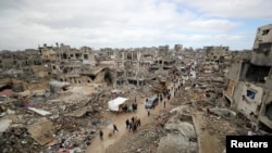 Palestinci prolaze pored srušenih zgrada u gradu Gaza, 6. februar 2025. (Foto: REUTERS/Dawoud Abu Alkas)