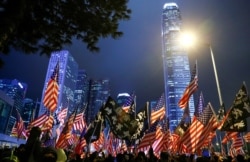 FILE - Protesters hold U.S. flags during a rally at Edinburgh Place, in Hong Kong, Nov. 28, 2019.