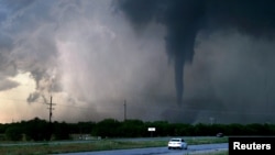 ARCHIVO - En la toma se aprecia un tornado mientras pasan autos en una autopista al oeste de Hawley, Texas. El 2 de mayo de 2024. Ronald W. Erdrich/Abilene Reporter-News/USA Today Network vía Reuters.