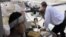 叙利亚自由军的一名战士在阿勒颇向政府军开火，另一名战士在掩体内