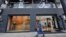 FILE - A man walks past a Nike shop on Venice Street in Benghazi, Libya, Nov. 7, 2013.