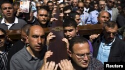 Christians carry a cross during a procession along the Via Dolorosa on Good Friday during Holy Week in Jerusalem's Old City, April 3, 2015. 