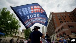 A supporter waves a flag prior to a campaign rally for President Donald Trump at the BOK Center in Tulsa, Okla., June 20, 2020.