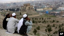 Foto yang diambil tanggal 27 Maret 2017, para pria tampak duduk di puncak bukit Nadir Khan dengan pandangan ke Kabul Afghanistan (foto: AP Photo/Rahmat Gul).