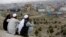 Men sit on the Nadir Khan hilltop overlooking Kabul, Afghanistan, March 27, 2017. American and Afghan officials are increasingly wary of the deepening ties between Russia and the Taliban that is fighting to topple the government in Kabul. 