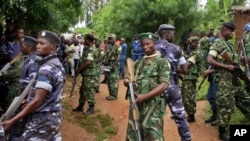 FILE - Amy soldiers and policemen attend the scene where more than 20 people were killed in their homes in an overnight attack in the Ruhagarika community of the rural northwestern province of Cibitoke, in Burundi, May 12, 2018.
