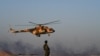 FILE - An Afghan Commando stands guard while an Afghan Air Force helicopter flies past during a combat training exercise in the Afghan province of Helmand, Aug. 27, 2017. An Afghan air force pilot was gunned down Dec. 30, 2020, in Kandahar.