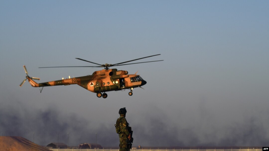 FILE - An Afghan Commando stands guard while an Afghan Air Force helicopter flies past during a combat training exercise in the Afghan province of Helmand, Aug. 27, 2017. An Afghan air force pilot was gunned down Dec. 30, 2020, in Kandahar.