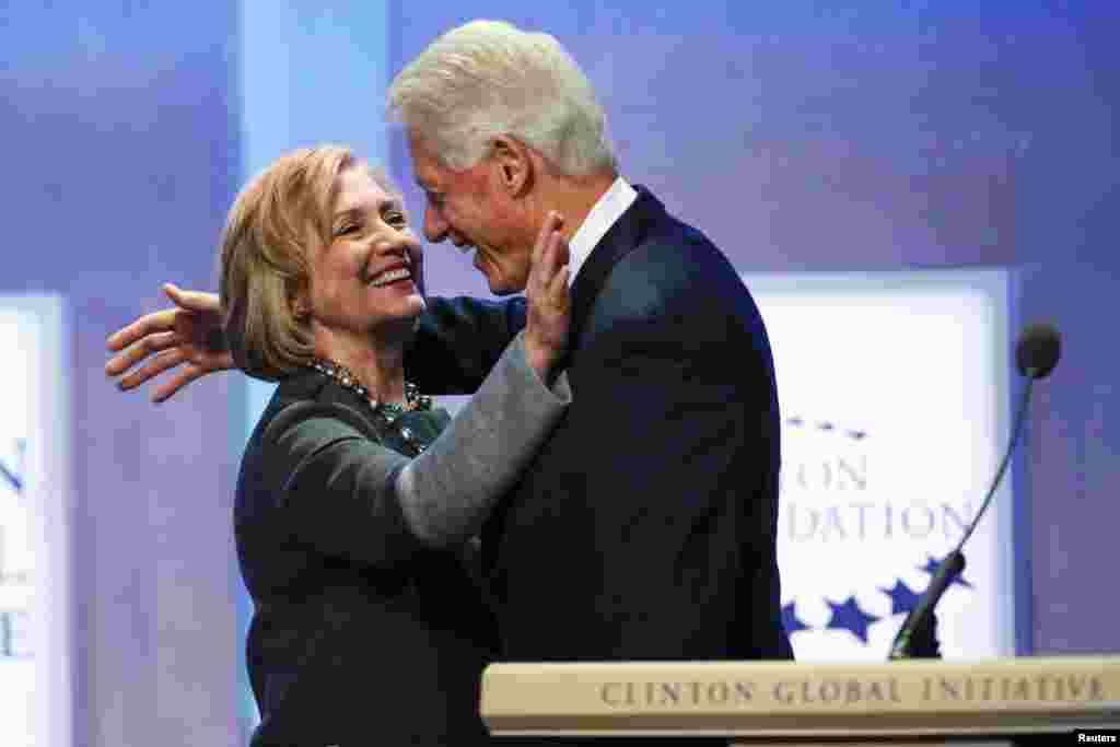 Former U.S. President Bill Clinton and former Secretary of State Hillary Clinton hug during the opening plenary session labeled &quot;Reimagining Impact&quot; at the Clinton Global Initiative 2014 (CGI) in New York. 