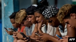 FILE - Young peeple use a hotspot to connect to the internet, in Havana, Cuba, June 6, 2019. 