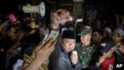 Seorang pemrotes mengangkat tinjunya dalam aksi demo anti-komunis di luar kantor Lembaga Bantuan Hukum (LBH) di Jakarta, Senin pagi, 18 September 2017. 