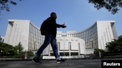 FILE: Seorang pria berjalan melewati kantor pusat Bank Rakyat China (PBOC), bank sentral, di Beijing, China, 28 September 2018. (Jason Lee/REUTERS)