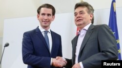 The leader of Austria's Green Party, Werner Kogler, right, and the head of the People's Party, Sebastian Kurz, shake hands after delivering a statement, in Vienna, Austria Jan. 1, 2020.