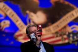 A member of the production team uses a light meter while on stage ahead of the first presidential debate between Republican candidate President Donald Trump and Democratic candidate former Vice President Joe Biden in Cleveland, Sep. 28, 2020.