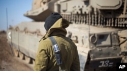 An Israeli soldier stand by a tank near the border with Syria in the Israeli-controlled Golan Heights, Nov. 28, 2016. A recent attack launched into northern Israel from Syria by militants apparently affiliated with IS have heightened fears in Israel.